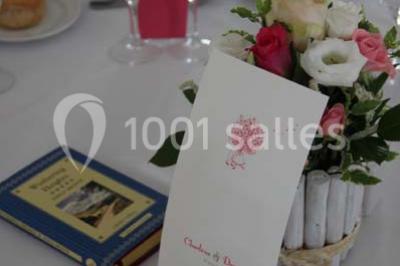 Miniature Traiteur Garancières (Yvelines) - Havane Traiteur #6 Table dressée avec nappes blanches, couverts, menus et bouquets de fleurs, entourée de chaises en bois dans une salle.