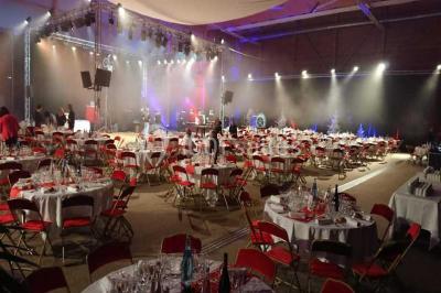 Miniature Traiteur Garancières (Yvelines) - Havane Traiteur #11 Table dressée avec nappes blanches, couverts, menus et bouquets de fleurs, entourée de chaises en bois dans une salle.