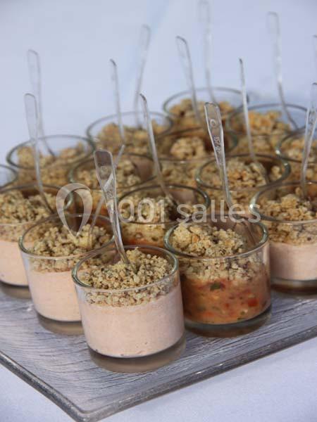 Verrines individuelles garnies de mousse et crumble, présentées avec des cuillères sur un plateau.