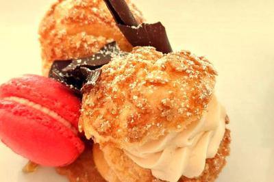 Miniature Traiteur Robion (Vaucluse) - Dupas Traiteur #7 Un serveur remplit un verre de boisson pour un homme lors d'un buffet avec des verrines et des invités en arrière-plan.