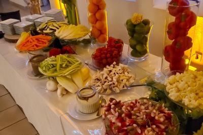 Miniature Traiteur Robion (Vaucluse) - Dupas Traiteur #10 Un serveur remplit un verre de boisson pour un homme lors d'un buffet avec des verrines et des invités en arrière-plan.