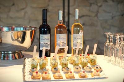 Miniature Traiteur Robion (Vaucluse) - Dupas Traiteur #11 Un serveur remplit un verre de boisson pour un homme lors d'un buffet avec des verrines et des invités en arrière-plan.