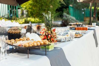 Miniature Traiteur Chaponost (Rhône) - Jacques Lafargue Traiteur #8 Une main coupe un rouleau de foie gras sur une planche en bois, entouré de figues et de tomates cerises.