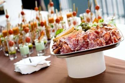 Miniature Traiteur Chaponost (Rhône) - Jacques Lafargue Traiteur #2 Une main coupe un rouleau de foie gras sur une planche en bois, entouré de figues et de tomates cerises.