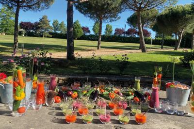 Miniature Traiteur Chaponost (Rhône) - Jacques Lafargue Traiteur #5 Une main coupe un rouleau de foie gras sur une planche en bois, entouré de figues et de tomates cerises.