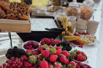 Miniature Traiteur Chaponost (Rhône) - Jacques Lafargue Traiteur #17 Une main coupe un rouleau de foie gras sur une planche en bois, entouré de figues et de tomates cerises.