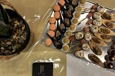 Miniature Traiteur Chaponost (Rhône) - Jacques Lafargue Traiteur #27 Une main coupe un rouleau de foie gras sur une planche en bois, entouré de figues et de tomates cerises.