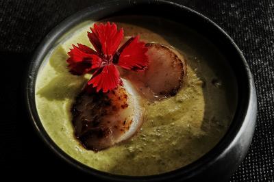 Miniature Traiteur Chaponost (Rhône) - Jacques Lafargue Traiteur #28 Une main coupe un rouleau de foie gras sur une planche en bois, entouré de figues et de tomates cerises.