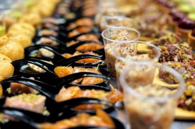 Miniature Traiteur Chaponost (Rhône) - Jacques Lafargue Traiteur #32 Une main coupe un rouleau de foie gras sur une planche en bois, entouré de figues et de tomates cerises.