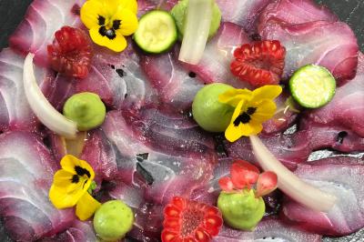 Tarte garnie de fruits frais variés, crème chantilly et feuilles de menthe, servie sur une assiette blanche.