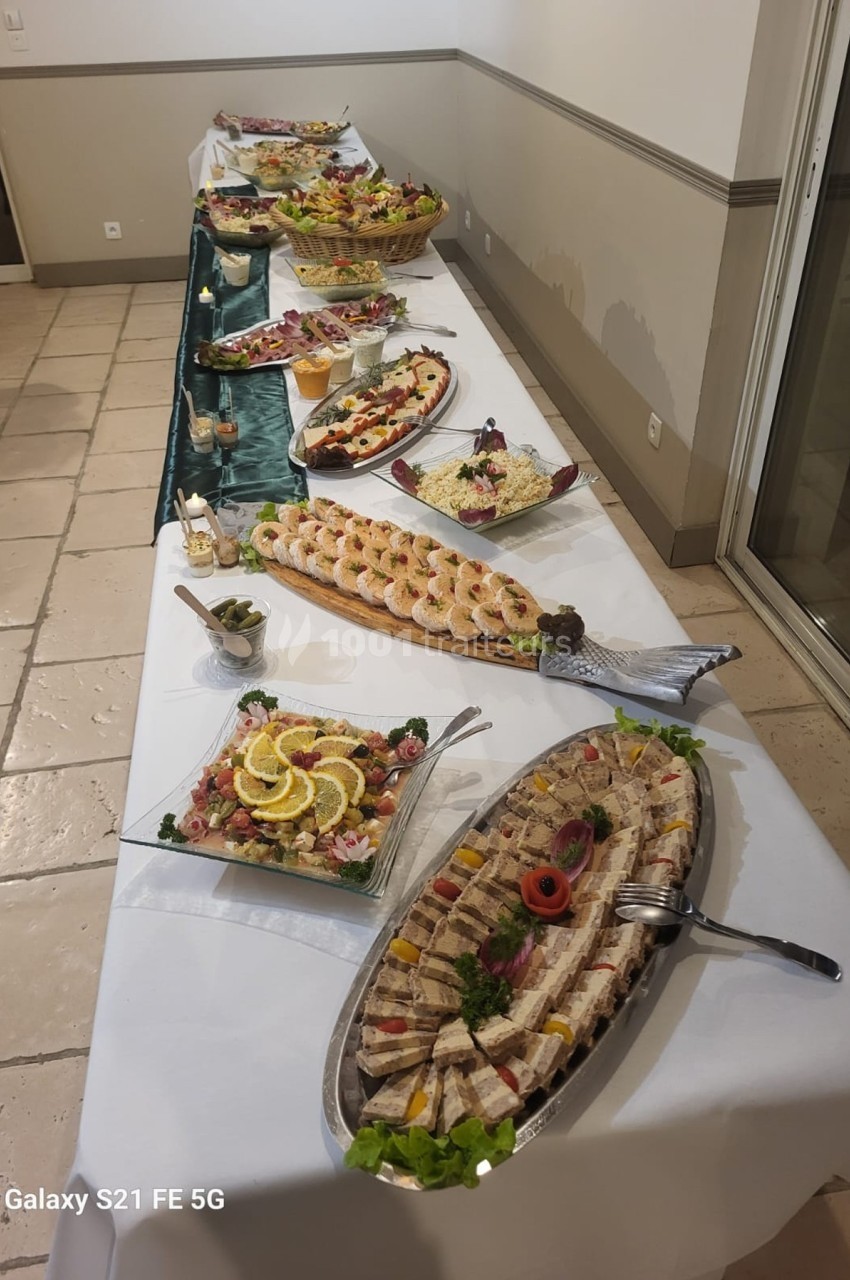 Buffet dressé avec divers plats froids, incluant des fruits de mer, salades et assortiments de charcuterie.