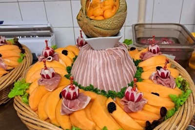 Assiette composée de foie gras, gelée, pain brioché, tranches d'orange, groseilles, jeunes pousses et graines noires.