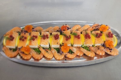 Assiette composée de foie gras, gelée, pain brioché, tranches d'orange, groseilles, jeunes pousses et graines noires.