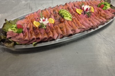 Assiette composée de foie gras, gelée, pain brioché, tranches d'orange, groseilles, jeunes pousses et graines noires.