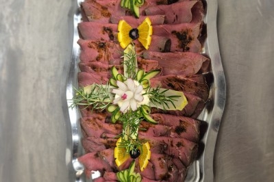 Assiette composée de foie gras, gelée, pain brioché, tranches d'orange, groseilles, jeunes pousses et graines noires.