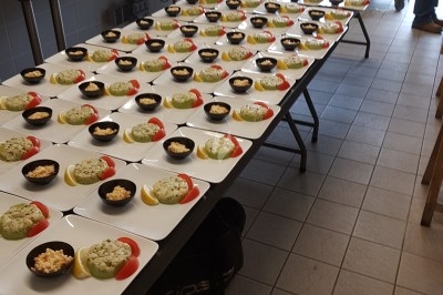 Assiette composée de foie gras, gelée, pain brioché, tranches d'orange, groseilles, jeunes pousses et graines noires.