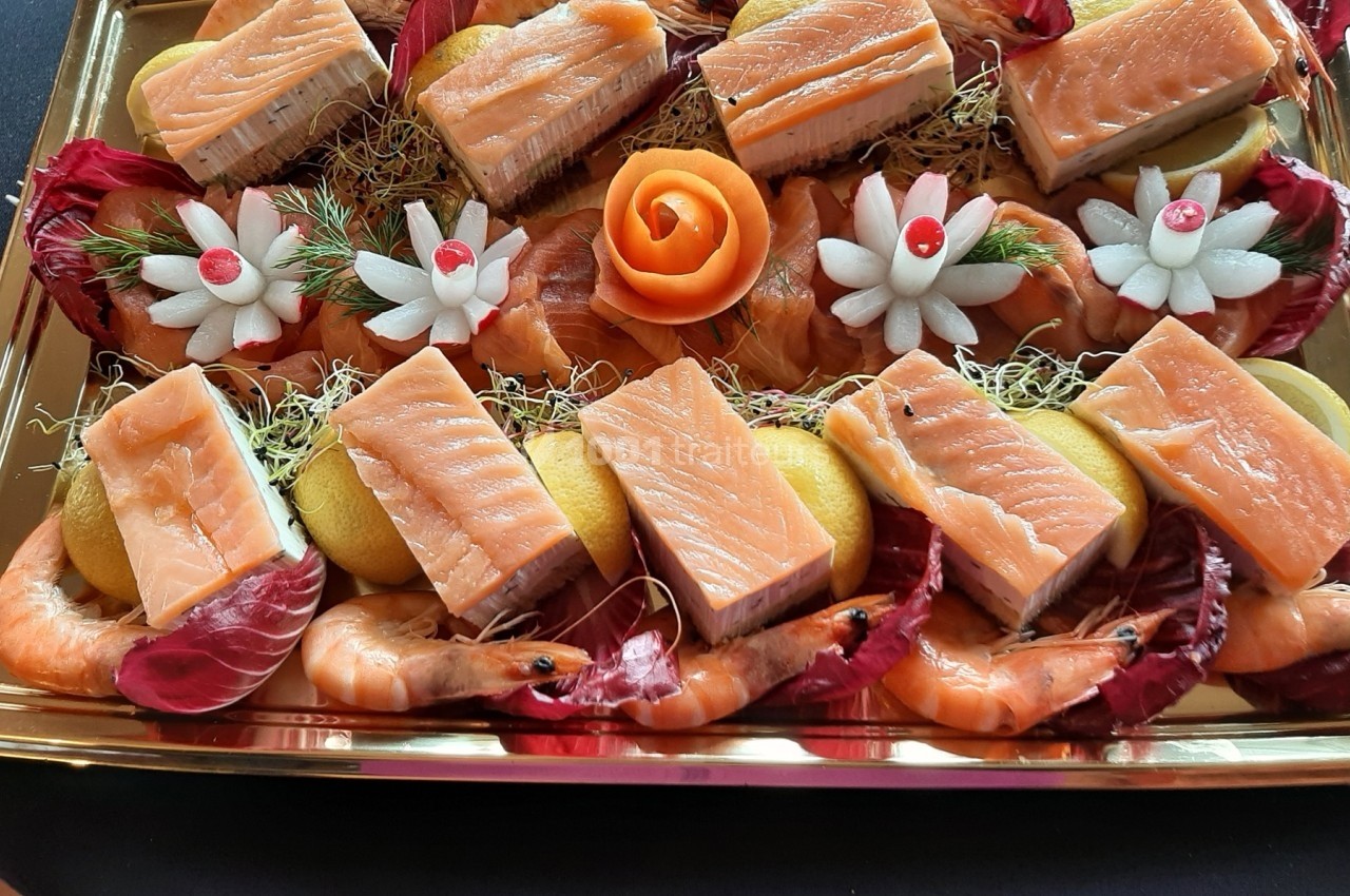 Plateau de saumon fumé, crevettes, radis sculptés et tranches de citron, décoré de feuilles de salade et d'une rose en…