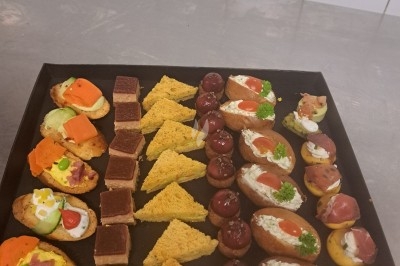 Assiette composée de foie gras, gelée, pain brioché, tranches d'orange, groseilles, jeunes pousses et graines noires.