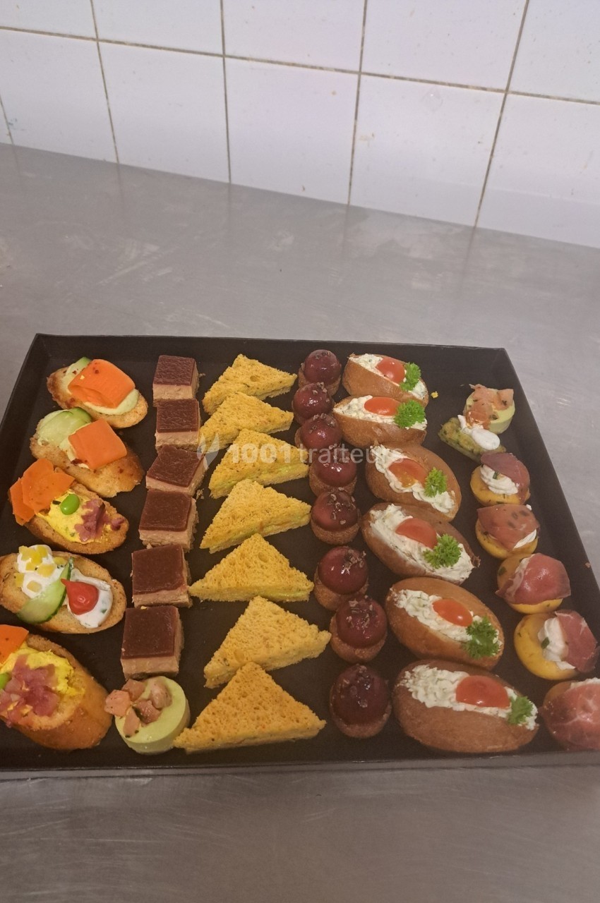 Plateau de canapés variés comprenant toasts, bouchées garnies et triangles de pain croustillant.