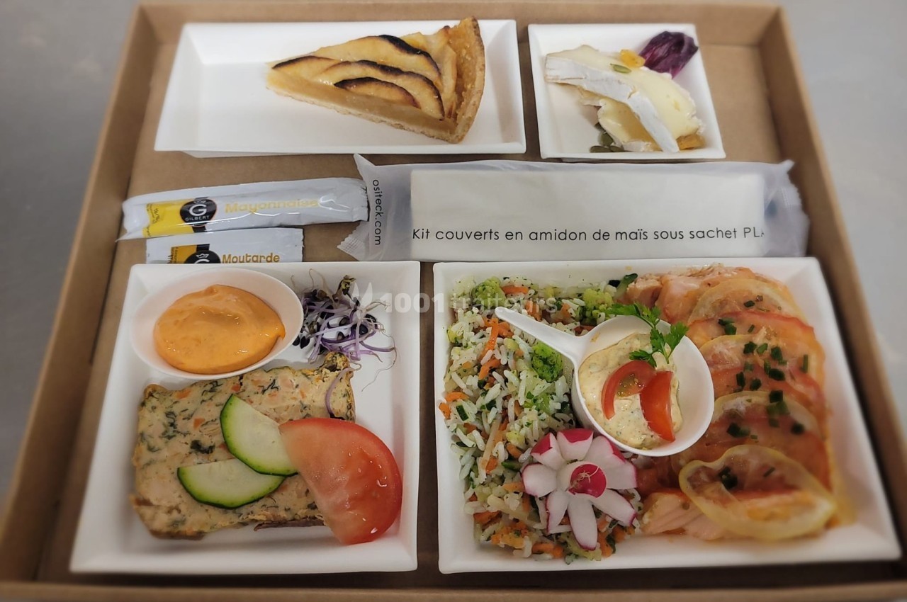 Plateau-repas composé de quiche, crudités, terrine, riz aux légumes, saumon fumé, dessert et couverts emballés.