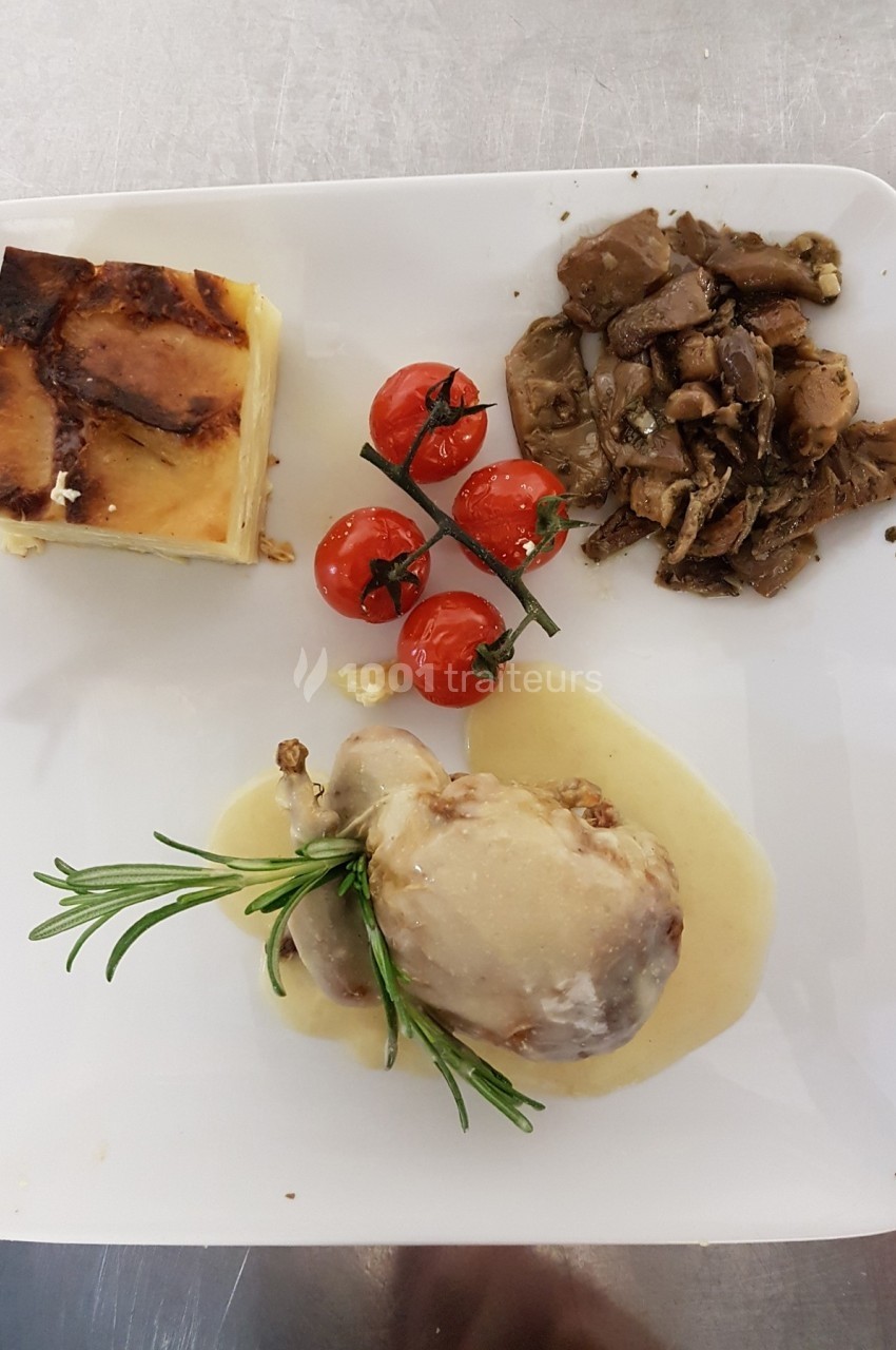 Assiette composée de viande en sauce, gratin, tomates cerises rôties et champignons sautés, présentée sur une table.