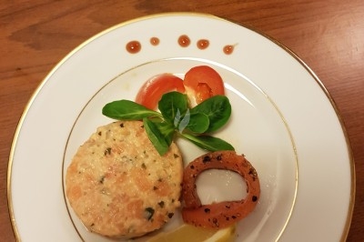 Assiette composée de foie gras, gelée, pain brioché, tranches d'orange, groseilles, jeunes pousses et graines noires.