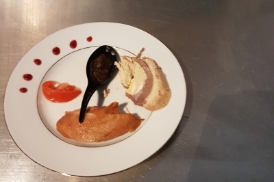 Assiette composée de foie gras, gelée, pain brioché, tranches d'orange, groseilles, jeunes pousses et graines noires.