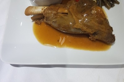 Assiette composée de foie gras, gelée, pain brioché, tranches d'orange, groseilles, jeunes pousses et graines noires.