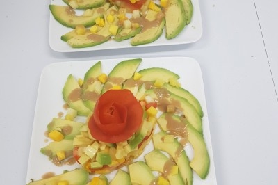 Assiette composée de foie gras, gelée, pain brioché, tranches d'orange, groseilles, jeunes pousses et graines noires.