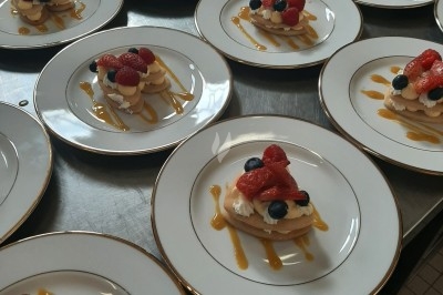 Assiette composée de foie gras, gelée, pain brioché, tranches d'orange, groseilles, jeunes pousses et graines noires.