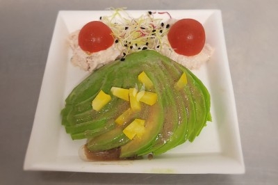 Assiette composée de foie gras, gelée, pain brioché, tranches d'orange, groseilles, jeunes pousses et graines noires.