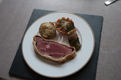 Assiette composée de foie gras, gelée, pain brioché, tranches d'orange, groseilles, jeunes pousses et graines noires.