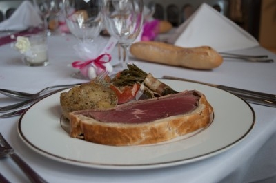 Assiette composée de foie gras, gelée, pain brioché, tranches d'orange, groseilles, jeunes pousses et graines noires.
