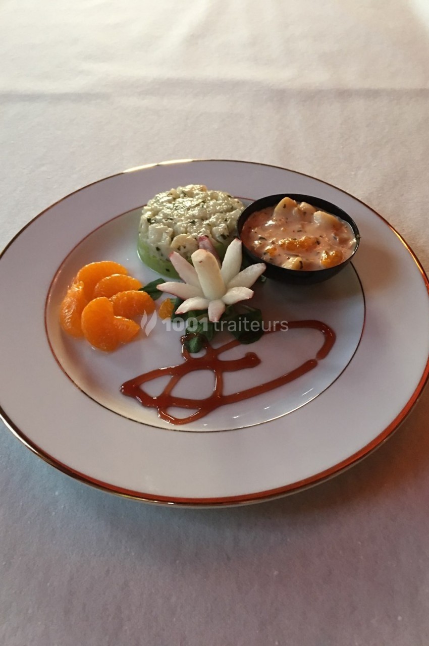 Assiette garnie de riz, segments de mandarine, sauce caramel, décoration florale et petite coupelle de gratin.