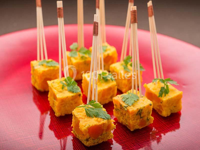Bouchées de tortilla aux légumes, présentées en cubes avec des piques en bois et décorées de feuilles de persil.