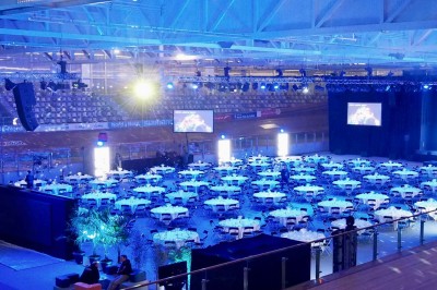 Miniature Traiteur Comines (Nord) - France Evenement Traiteur #4 Salle de réception éclairée en bleu avec des tables rondes dressées et des écrans disposés autour.