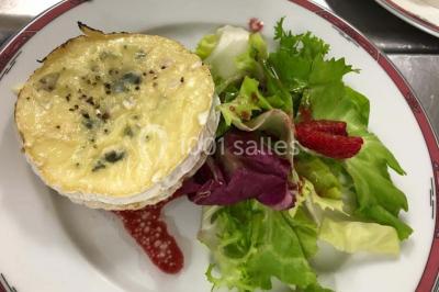 Table décorée pour un dîner, avec nappes blanches, serviettes pliées, lanternes, fleurs et couverts disposés.