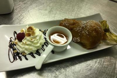 Table décorée pour un dîner, avec nappes blanches, serviettes pliées, lanternes, fleurs et couverts disposés.