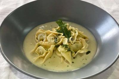 Table décorée pour un dîner, avec nappes blanches, serviettes pliées, lanternes, fleurs et couverts disposés.