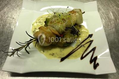 Table décorée pour un dîner, avec nappes blanches, serviettes pliées, lanternes, fleurs et couverts disposés.