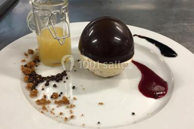 Table décorée pour un dîner, avec nappes blanches, serviettes pliées, lanternes, fleurs et couverts disposés.