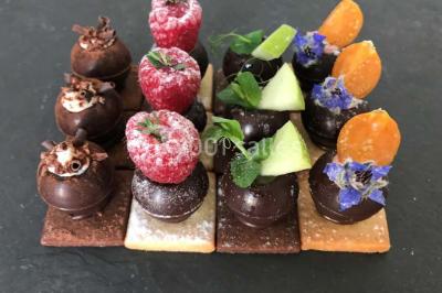 Miniature Traiteur Rueil-Malmaison (Hauts-de-Seine) - Cocktail Cocktail - Mets Tendances #7 Gros plan sur un macaron rouge garni de crème blanche, posé sur une surface sombre.