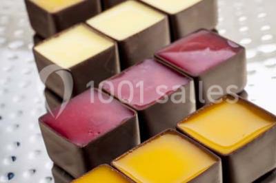 Miniature Traiteur Rueil-Malmaison (Hauts-de-Seine) - Cocktail Cocktail - Mets Tendances #8 Gros plan sur un macaron rouge garni de crème blanche, posé sur une surface sombre.