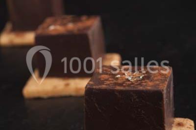 Miniature Traiteur Rueil-Malmaison (Hauts-de-Seine) - Cocktail Cocktail - Mets Tendances #9 Gros plan sur un macaron rouge garni de crème blanche, posé sur une surface sombre.