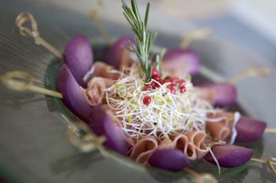 Miniature Traiteur Rueil-Malmaison (Hauts-de-Seine) - Cocktail Cocktail - Mets Tendances #11 Gros plan sur un macaron rouge garni de crème blanche, posé sur une surface sombre.