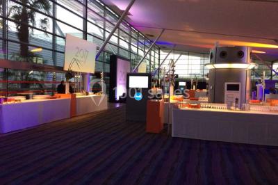 Gros plan sur un macaron rouge garni de crème blanche, posé sur une surface sombre.