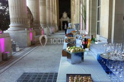 Gros plan sur un macaron rouge garni de crème blanche, posé sur une surface sombre.