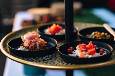 Miniature Traiteur Aubeterre (Aube) - Au Bois du Bon Sejour #15 Un chef cuisine sur un brasero dans un jardin, entouré de tables et de végétation.