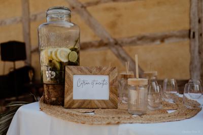 Miniature Traiteur Aubeterre (Aube) - Au Bois du Bon Sejour #17 Un chef cuisine sur un brasero dans un jardin, entouré de tables et de végétation.