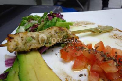 Un couple coupe un gâteau de mariage entouré de desserts décorés et de cierges magiques allumés.